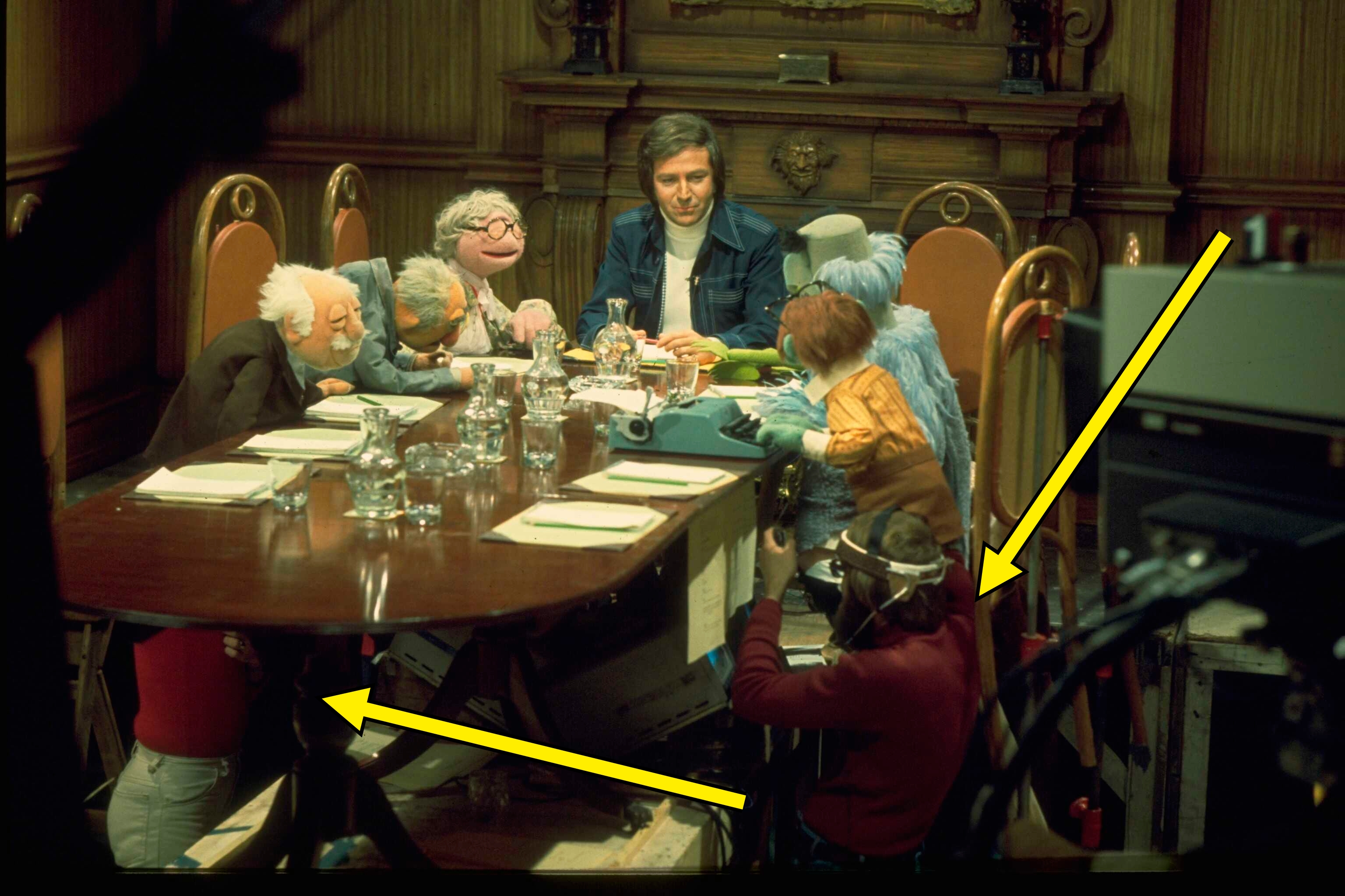 Person astatine a array with Muppet characters during a filming session. Puppeteers and cameras are disposable successful the scene