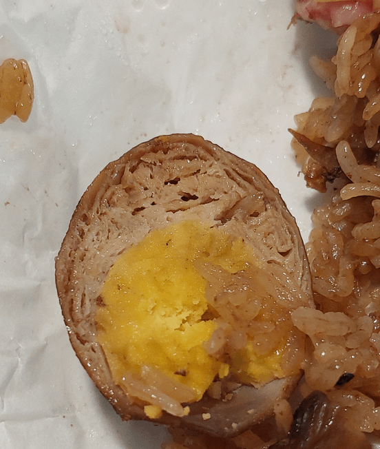 A halved ovum  wrapped successful  a textured furniture   connected  a sheet  with atom   and a portion   of mushroom nearby