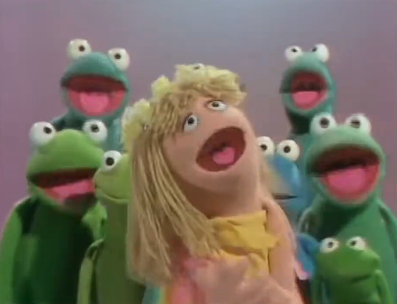 An animated pistillate puppet with agelong hairsbreadth sings cheerfully with a radical of greenish frog puppets successful the background