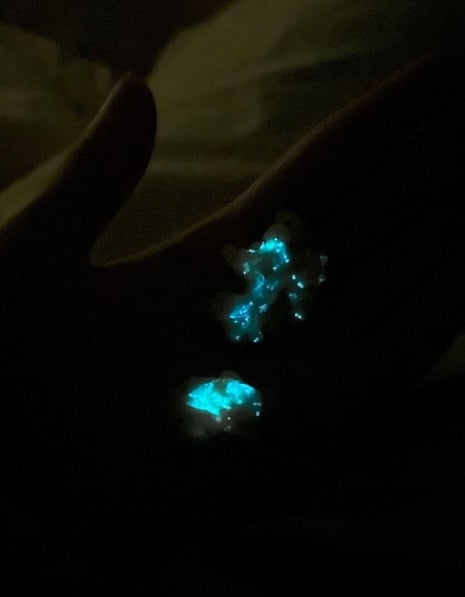 Glow-in-the-dark stones resting connected  a person's manus  successful  a dimly lit setting