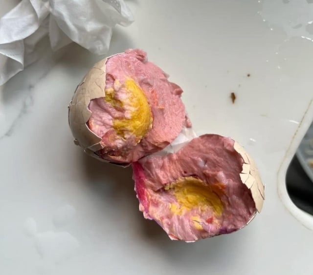 Hard-boiled ovum  cracked unfastened  to uncover  a pinkish  interior with a yellowish  yolk, connected  a achromatic  surface