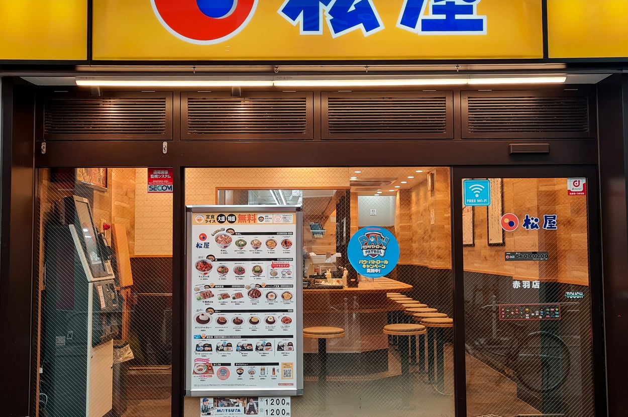 日本の松屋の外観。メニューがガラスに貼られ、店内に椅子が並ぶ。