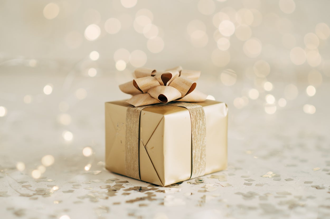 キラキラした背景に置かれたリボン付きのギフトボックス。