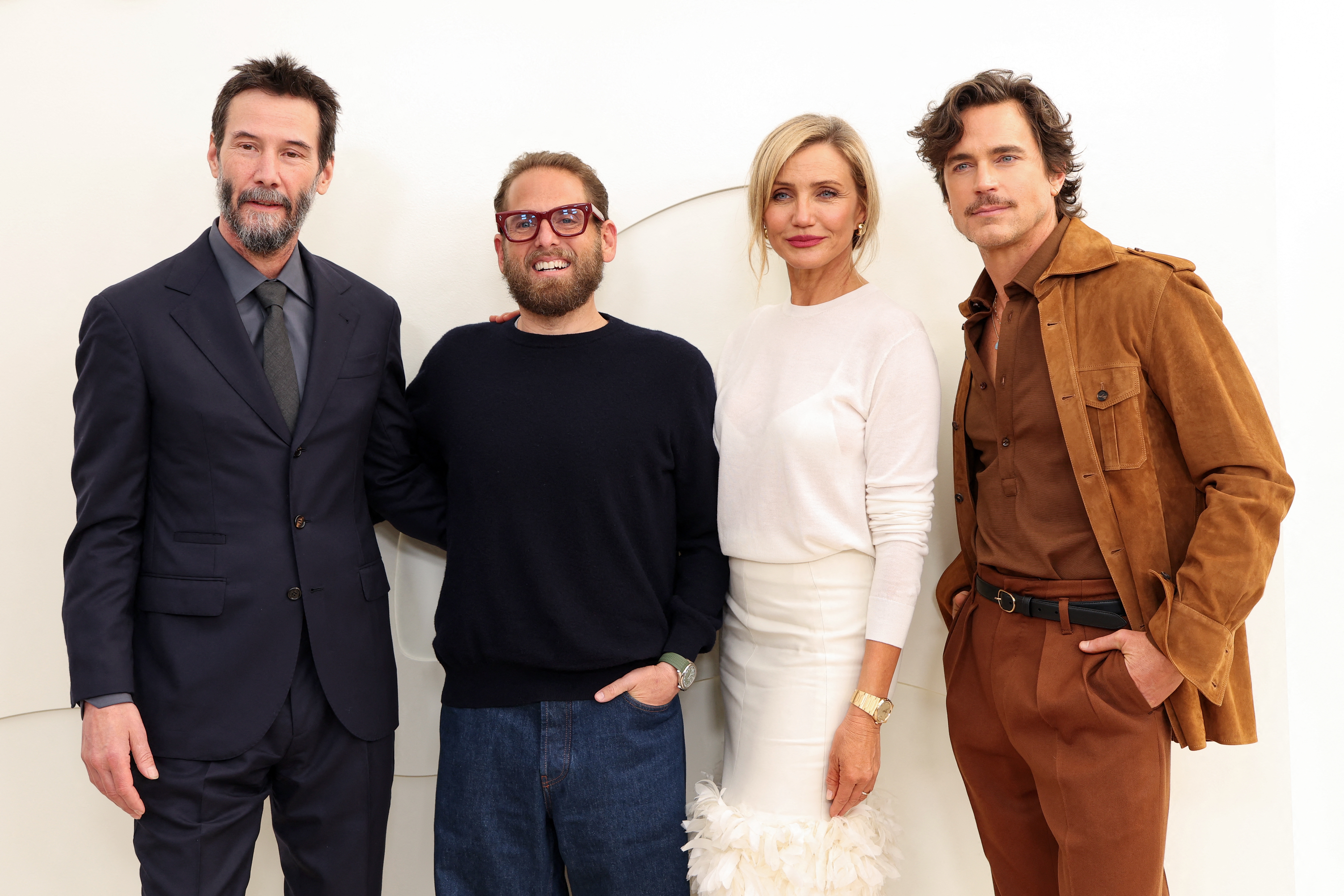 Four radical   are posing together; 1  is successful  a suit, different  successful  a sweater, the 3rd  successful  an elegant outfit, and the 4th  successful  a casual suede jacket