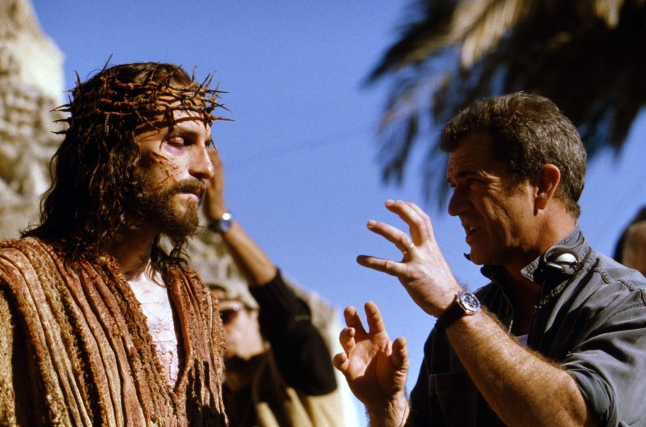 Person dressed arsenic  Jesus with a crown of thorns speaks to a manager  who gestures animatedly during a movie  shoot