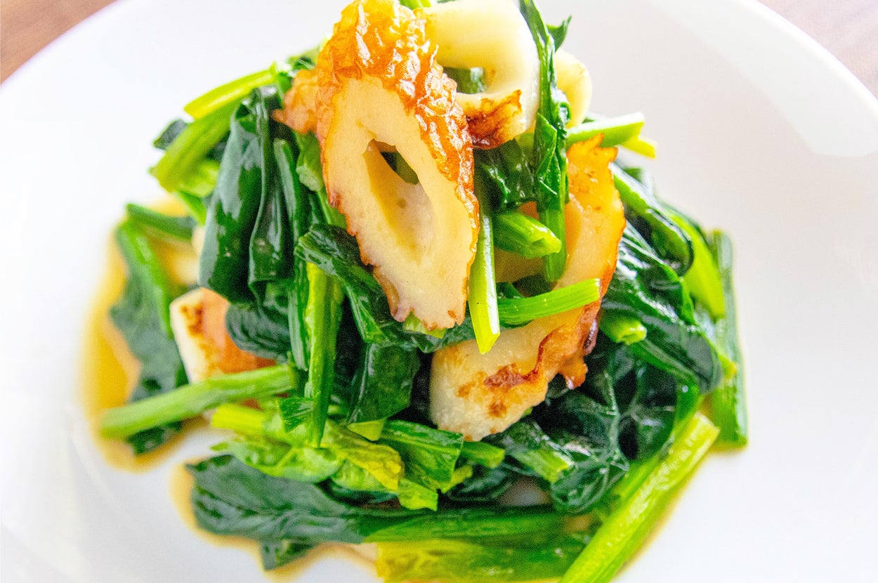 緑の野菜と竹輪を使った料理が白い皿に盛り付けられています。