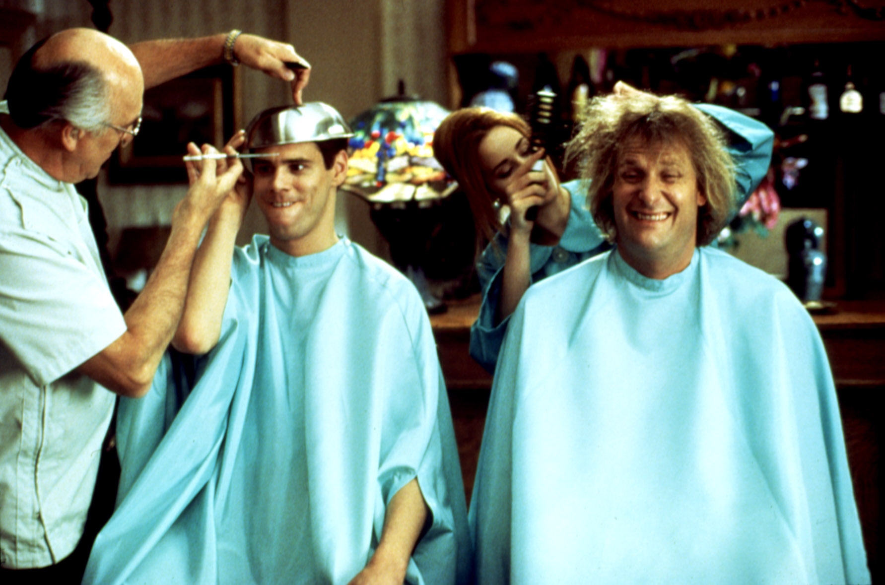 Three people getting quirky haircuts with a bowl and clippers, smiling with playful expressions