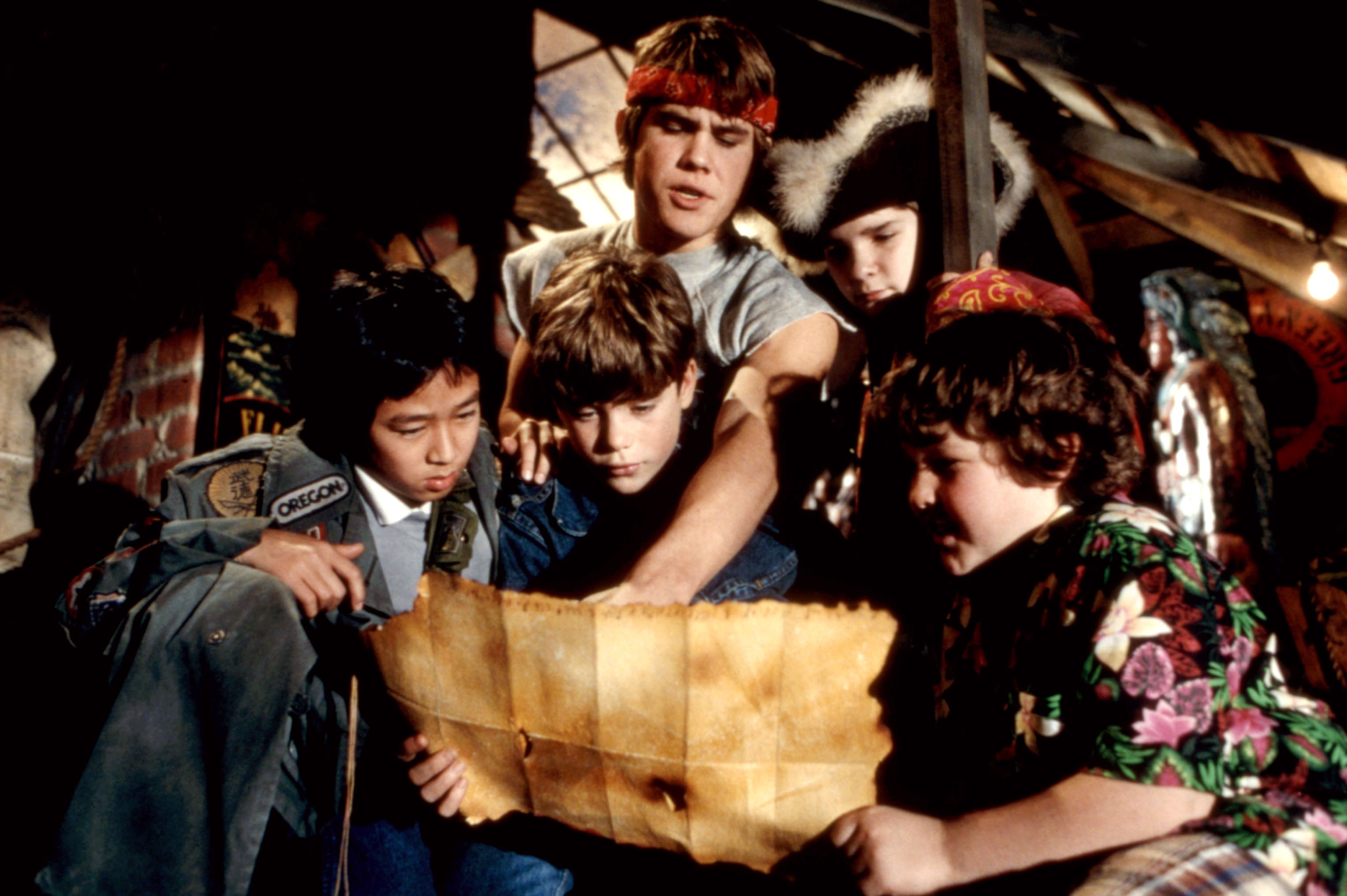 A group of kids in an attic intently examining a treasure map, appearing adventurous and curious