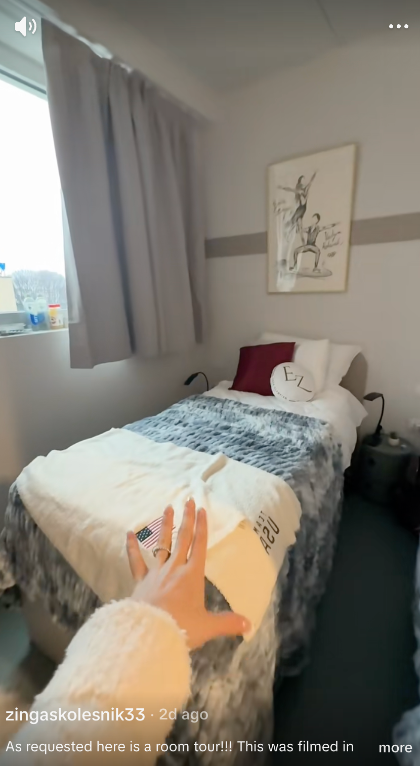 Cozy chamber  circuit  with a neatly made bed, brushed  blankets, and a manus  reaching into the frame. Modern creation  hangs supra  the bed