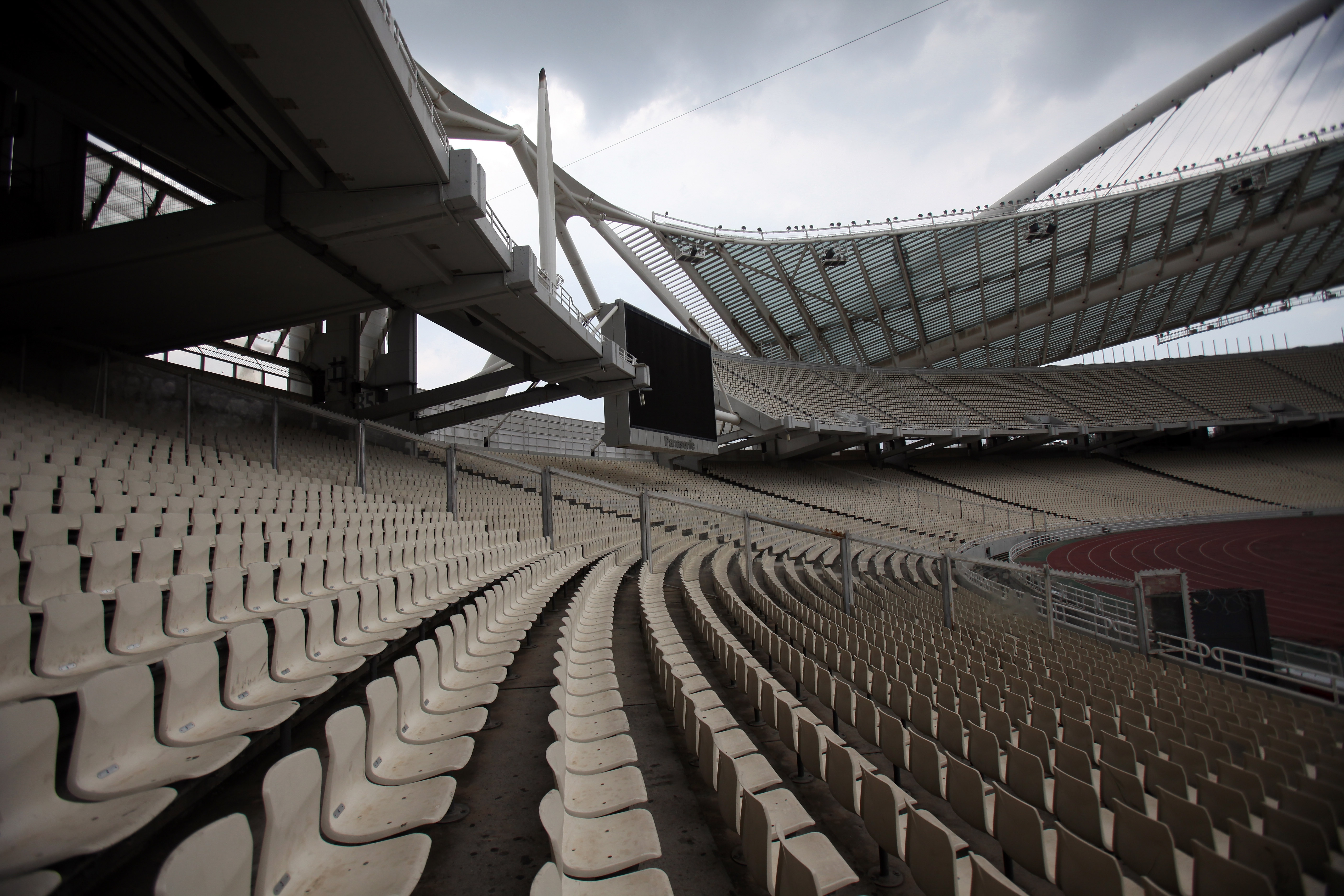 Empty stadium seating with a view of the expansive architectural roof structure, conveying a sense of solitude and anticipation
