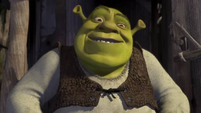 Animated quality  Shrek smiling, wearing a rustic vest implicit    a long-sleeved shirt, lasting  extracurricular  a woody  structure