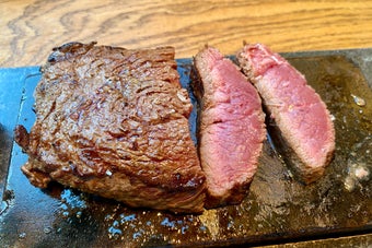 ステーキがカットされ、石板の上に置かれた様子。肉はジューシーで、焼き加減はレア。