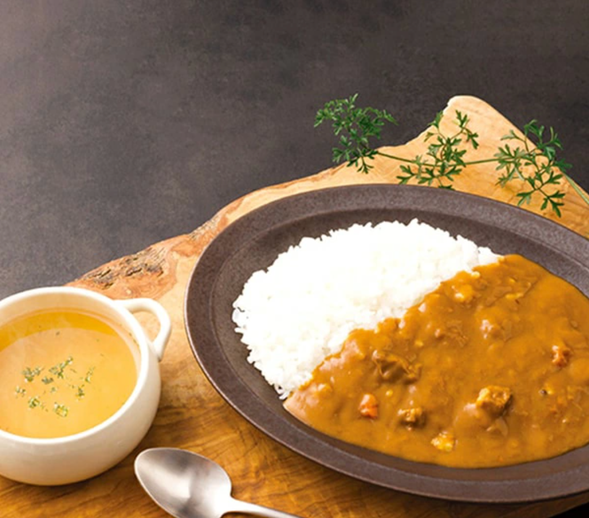 カレーライスとスープが木製トレイに乗っている。