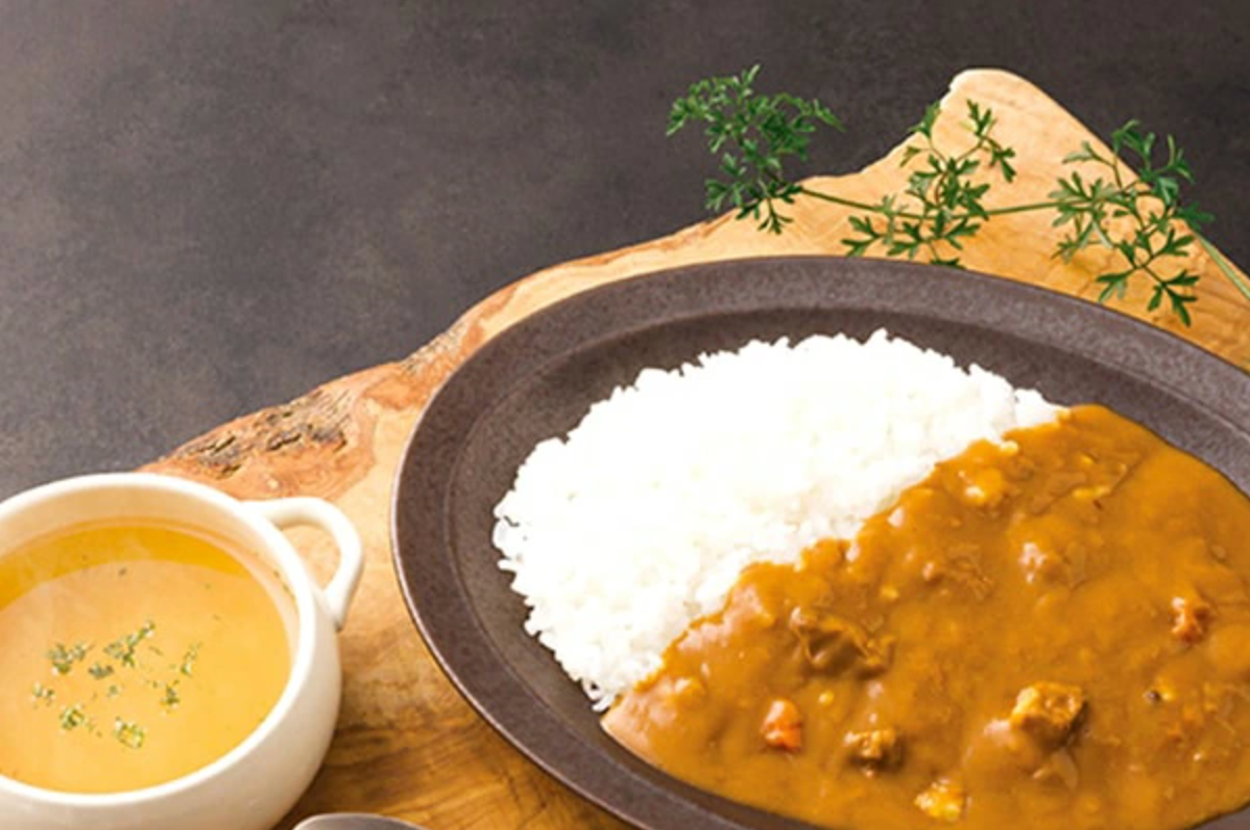 カレーライスとスープが木製トレイに乗っている。