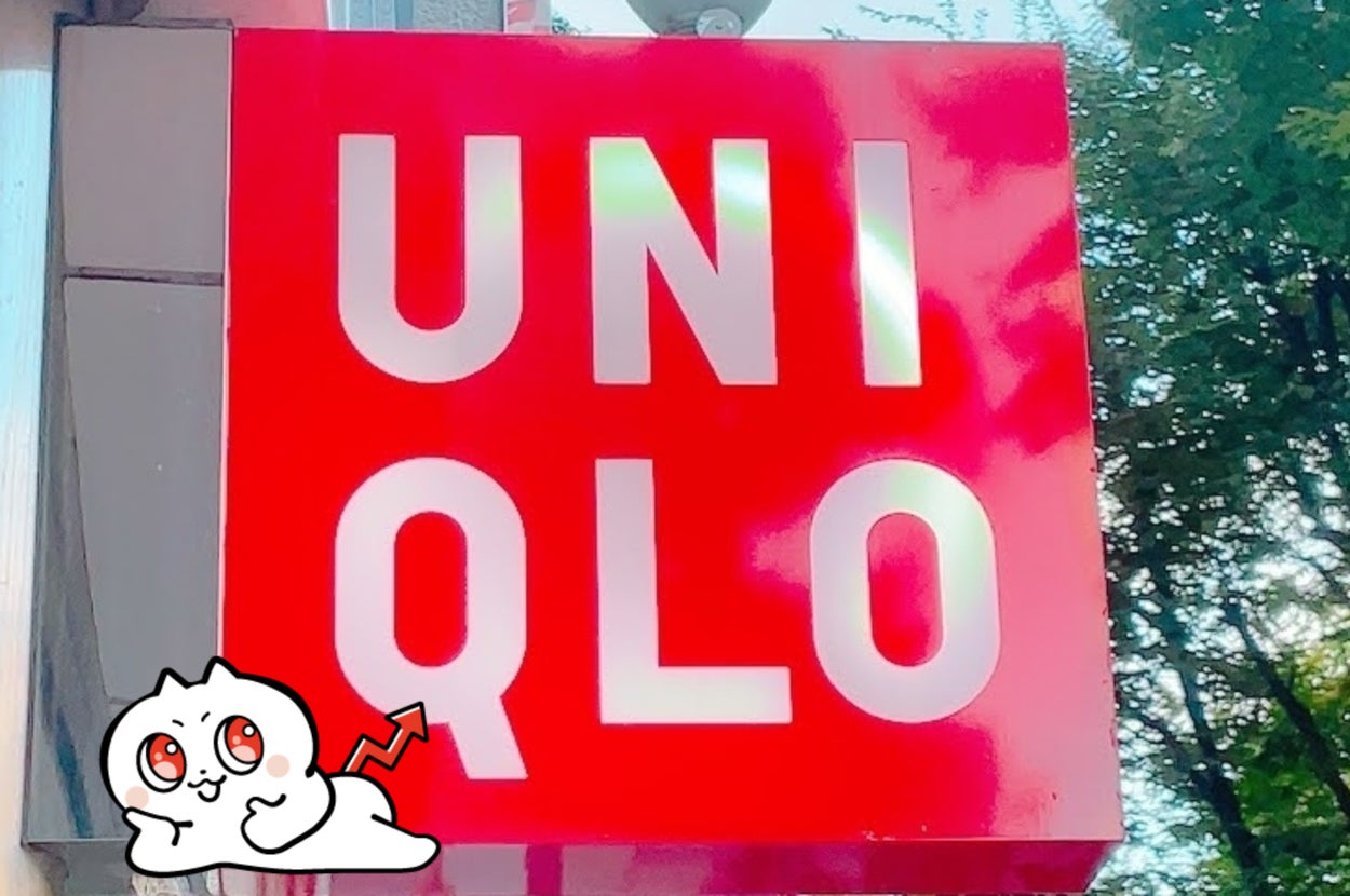 ユニクロ店舗の赤い看板が屋外に設置されています。背景には木々が見えます。