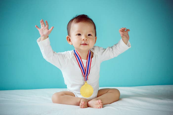Baby wearing a ample  golden  medal
