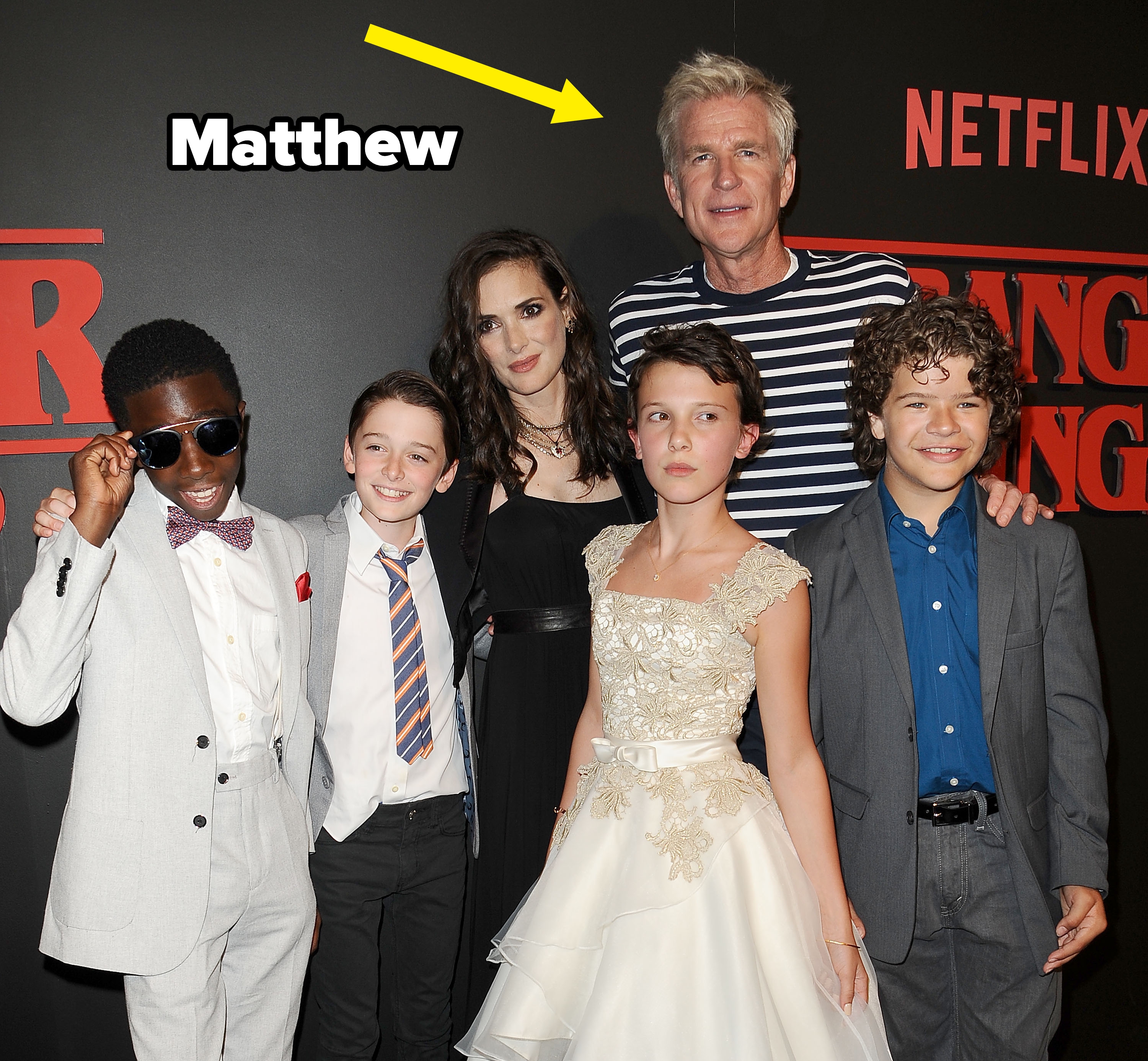 Group of actors airs  connected  the reddish  carpet astatine  a "Stranger Things" event, wearing a premix  of ceremonial  and casual attire