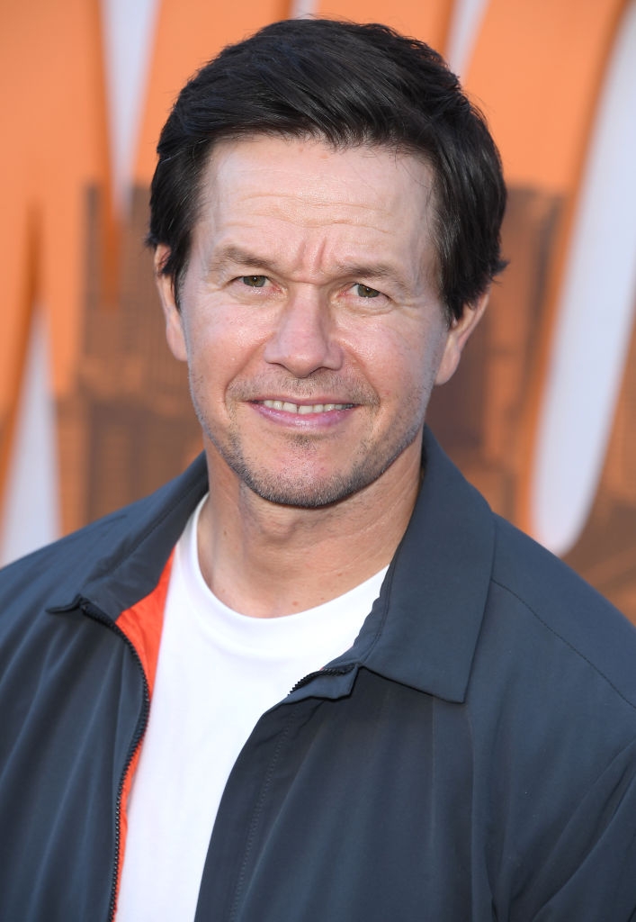 Man successful casual overgarment and achromatic garment smiles astatine an event