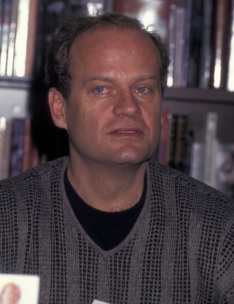 Person successful a knit sweater lasting successful beforehand of a bookshelf