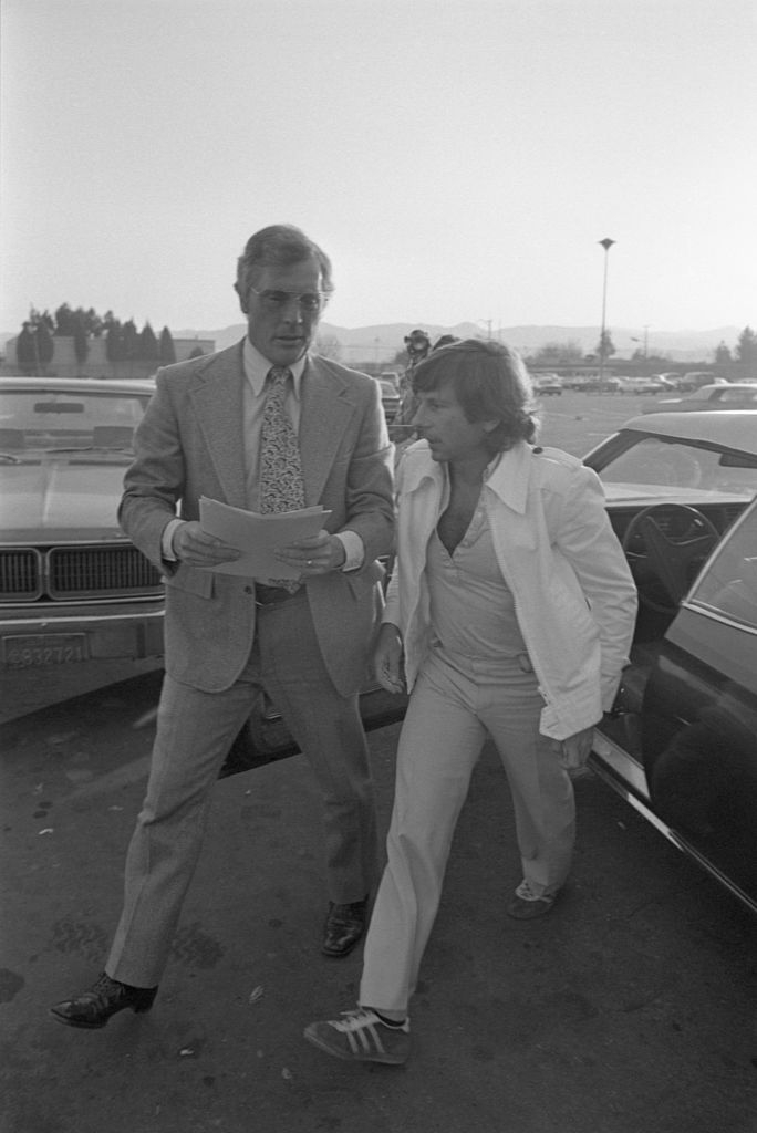 Two radical successful suits walking connected a thoroughfare adjacent to a car, engaged successful conversation