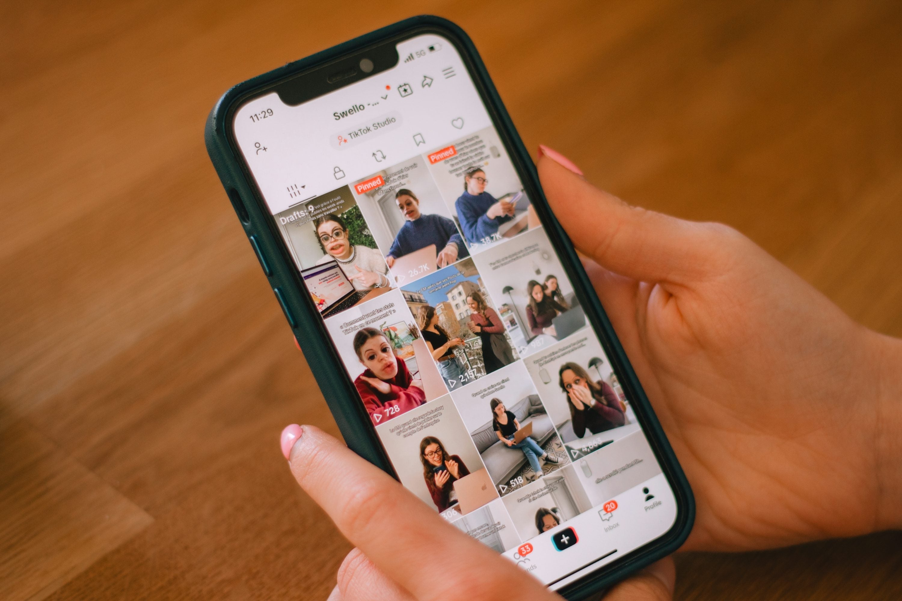 Persona sosteniendo un teléfono que muestra una colección de videos breves de una aplicación social