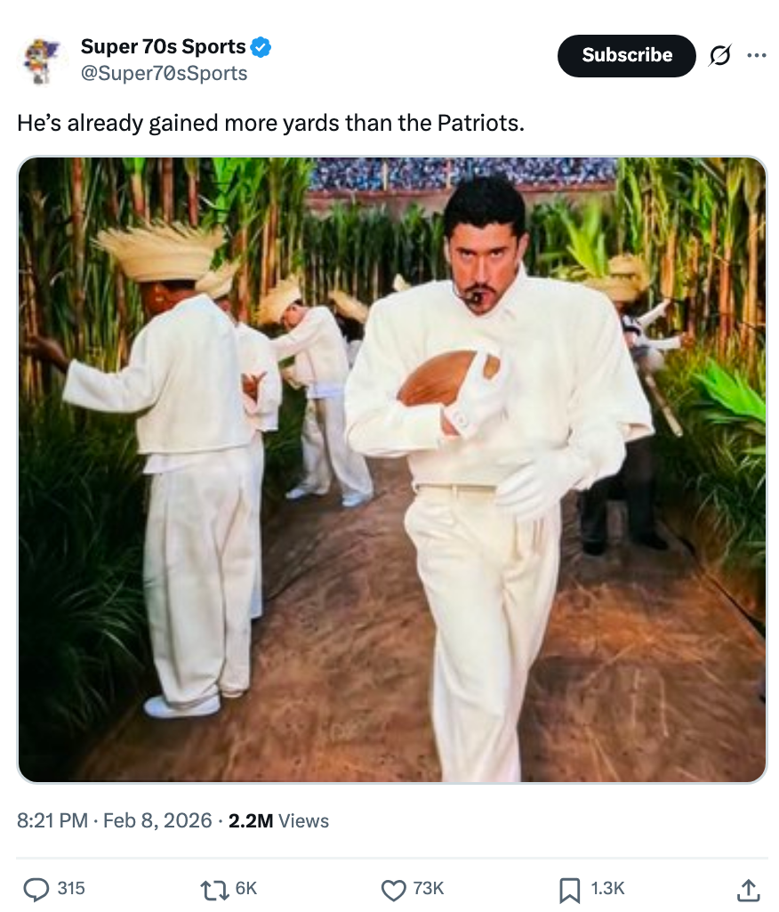 Bad Bunny in a suit holding a football, walking through a lush, jungle-like setting. Background shows others dressed in white suits. Caption references Patriots