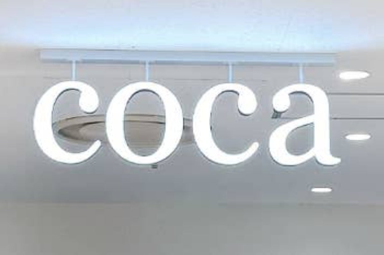 「coca」と書かれた照明看板が天井から吊るされています。