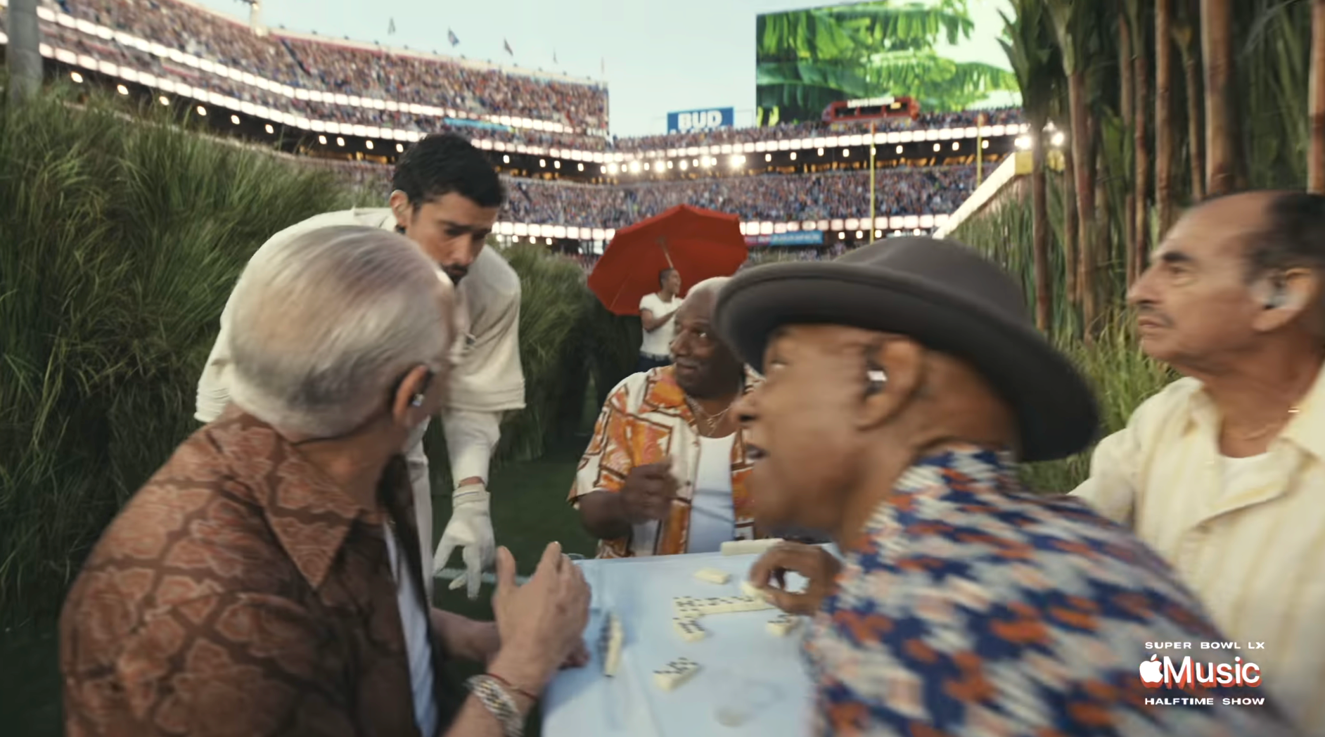 Several older adults play   dominoes astatine  a stadium surrounded by cheering crowds and lush decorations