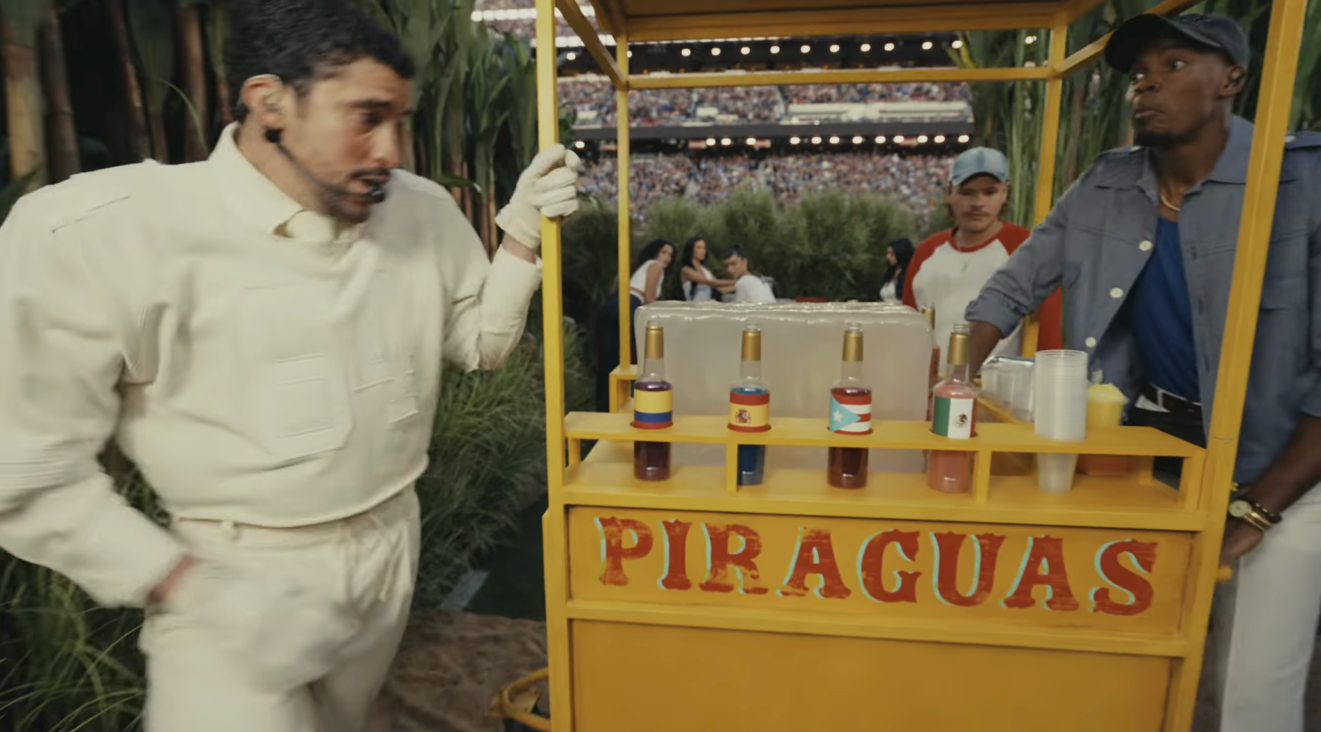 Man successful  a racing outfit approaches a cart labeled "PIRAGUAS" with colorful syrups. An attendant successful  casual attire stands beside the cart