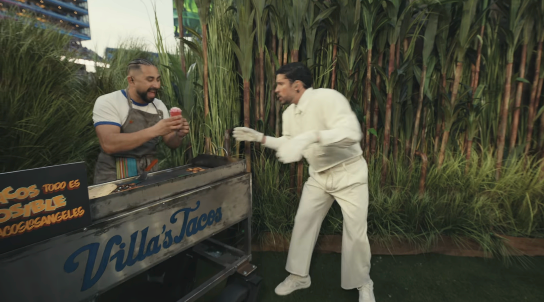 A idiosyncratic   successful  a taco costume eagerly reaches for a taco from a vendor astatine  an outdoor stand