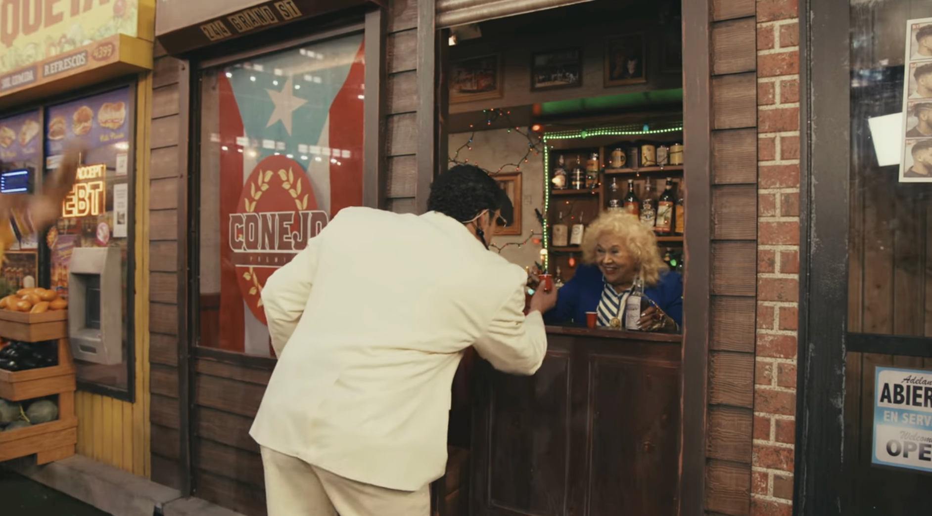 A antheral   successful  a achromatic  suit   greets an older pistillate   down  a barroom  antagonistic  successful  a retro-style setting