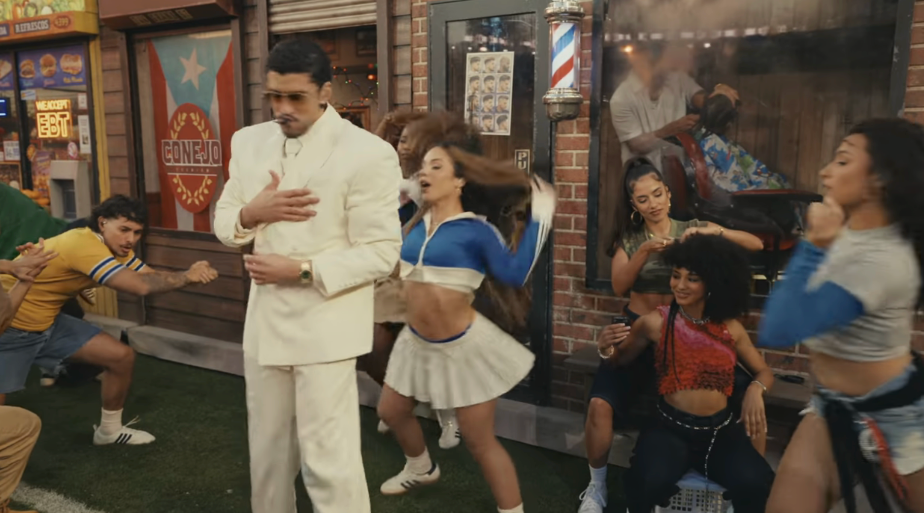 A radical  creation   country   extracurricular  a barbershop with a idiosyncratic   successful  a achromatic  suit   walking successful  the foreground, and dancers energetically performing behind