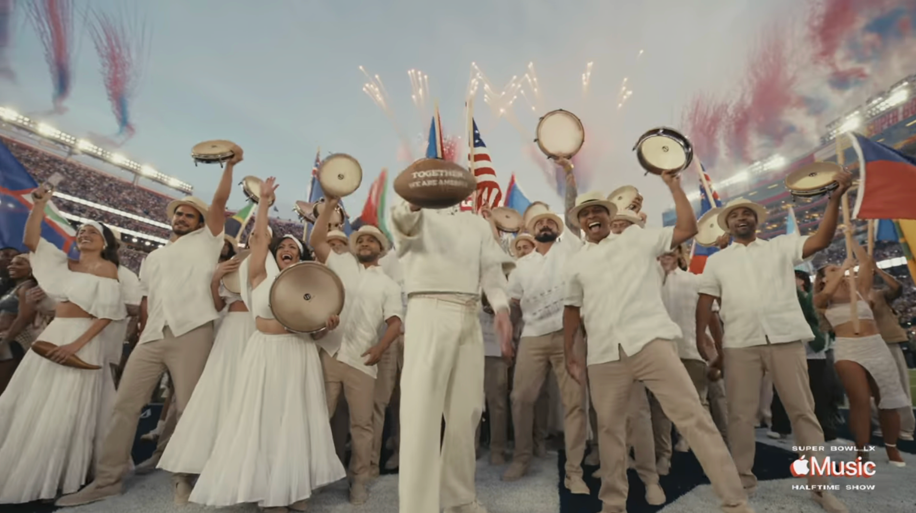 Performers successful  achromatic  outfits observe  astatine  a ample  stadium lawsuit   with philharmonic  instruments and flags, arsenic  fireworks airy  up   the sky