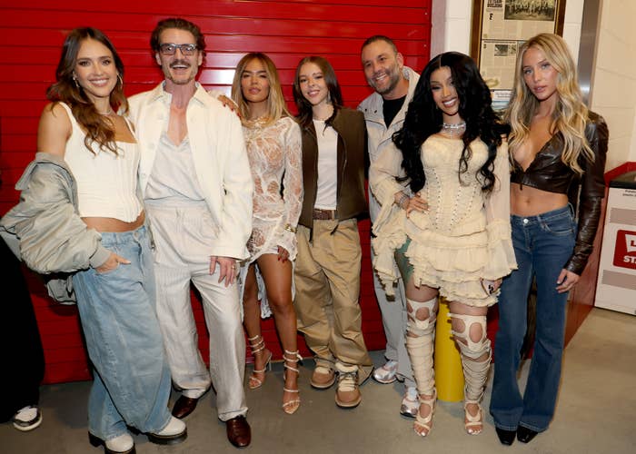 Group of 7  radical   successful  a casual backstage setting. They are dressed successful  a premix  of casual and edgy styles, with immoderate   wearing layered outfits and lace