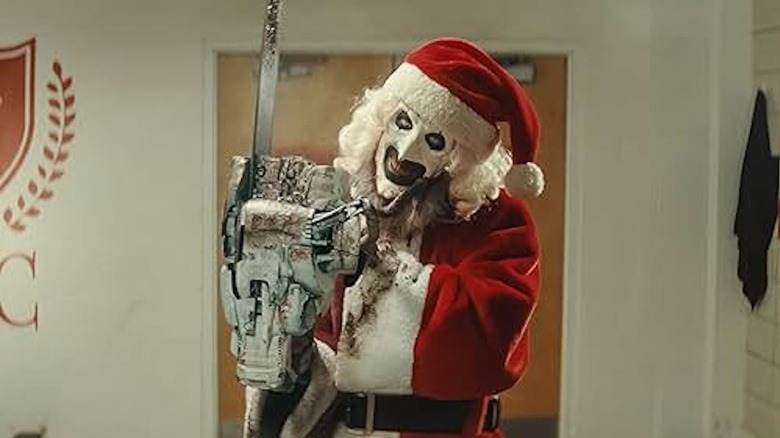 Creepy clown successful  a Santa suit   holding a chainsaw, indoors with a partition  logo successful  the background