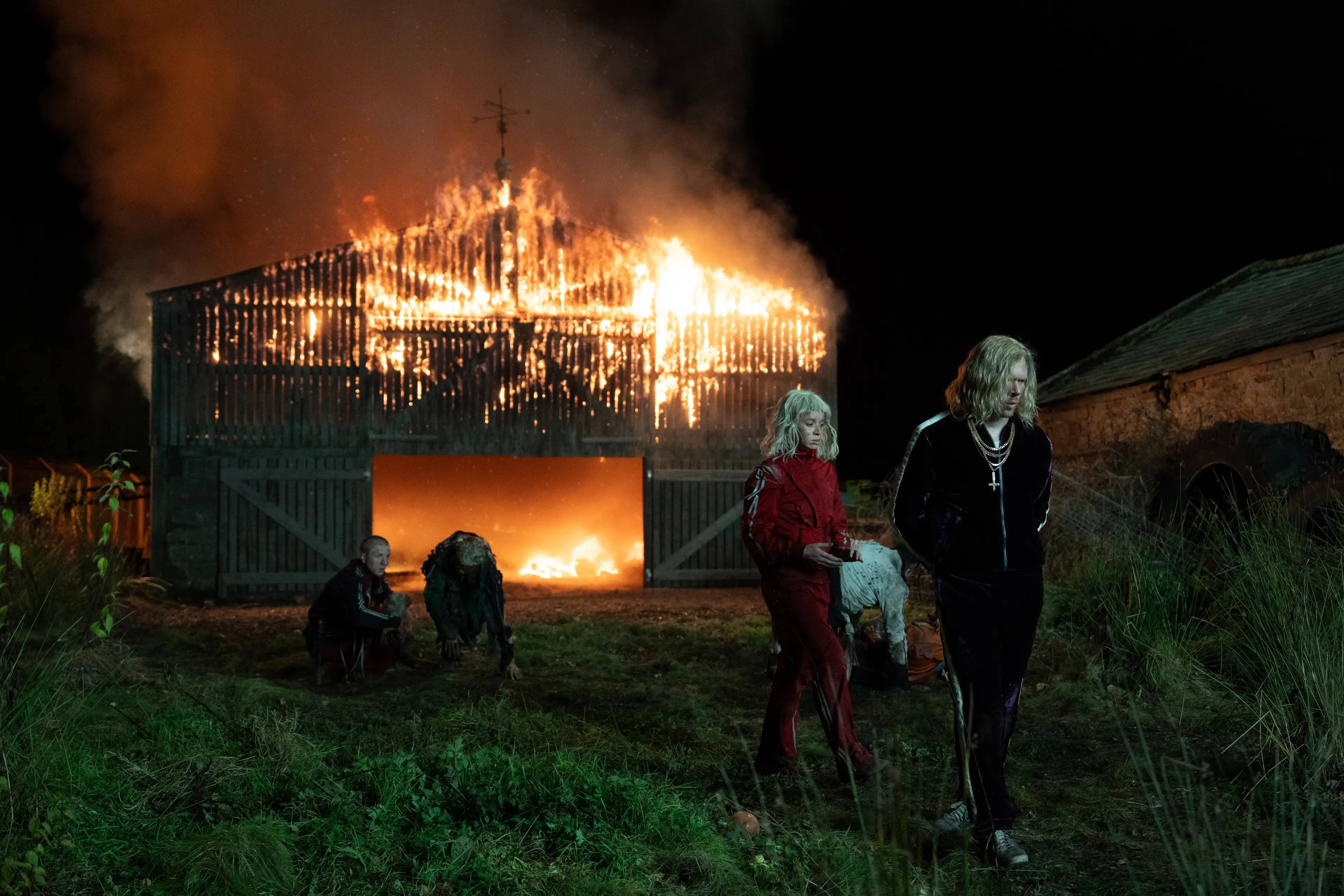 People successful  bold outfits pb  sheep distant  from a barn engulfed successful  flames astatine  night