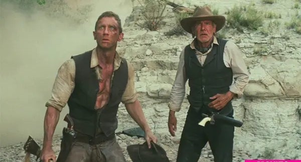 Two men successful  dusty occidental  attire basal   alert successful  a rugged terrain, holding weapons