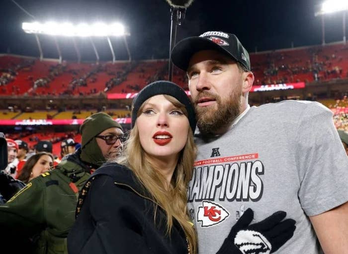 I don't know who these people are, but a man in sports gear and a woman in casual winter attire stand together in a stadium after a sports event