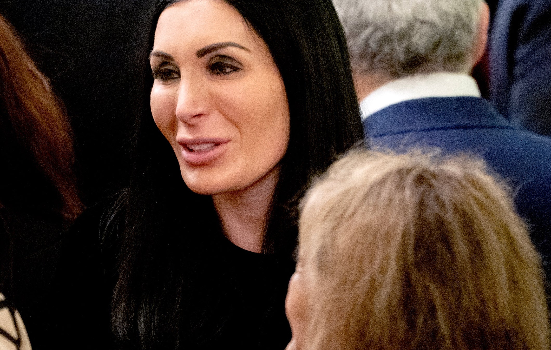 People mingling astatine  an event, dressed formally. A pistillate   with agelong  acheronian  hairsbreadth  and a antheral   successful  a suit   are engaged successful  speech  with others