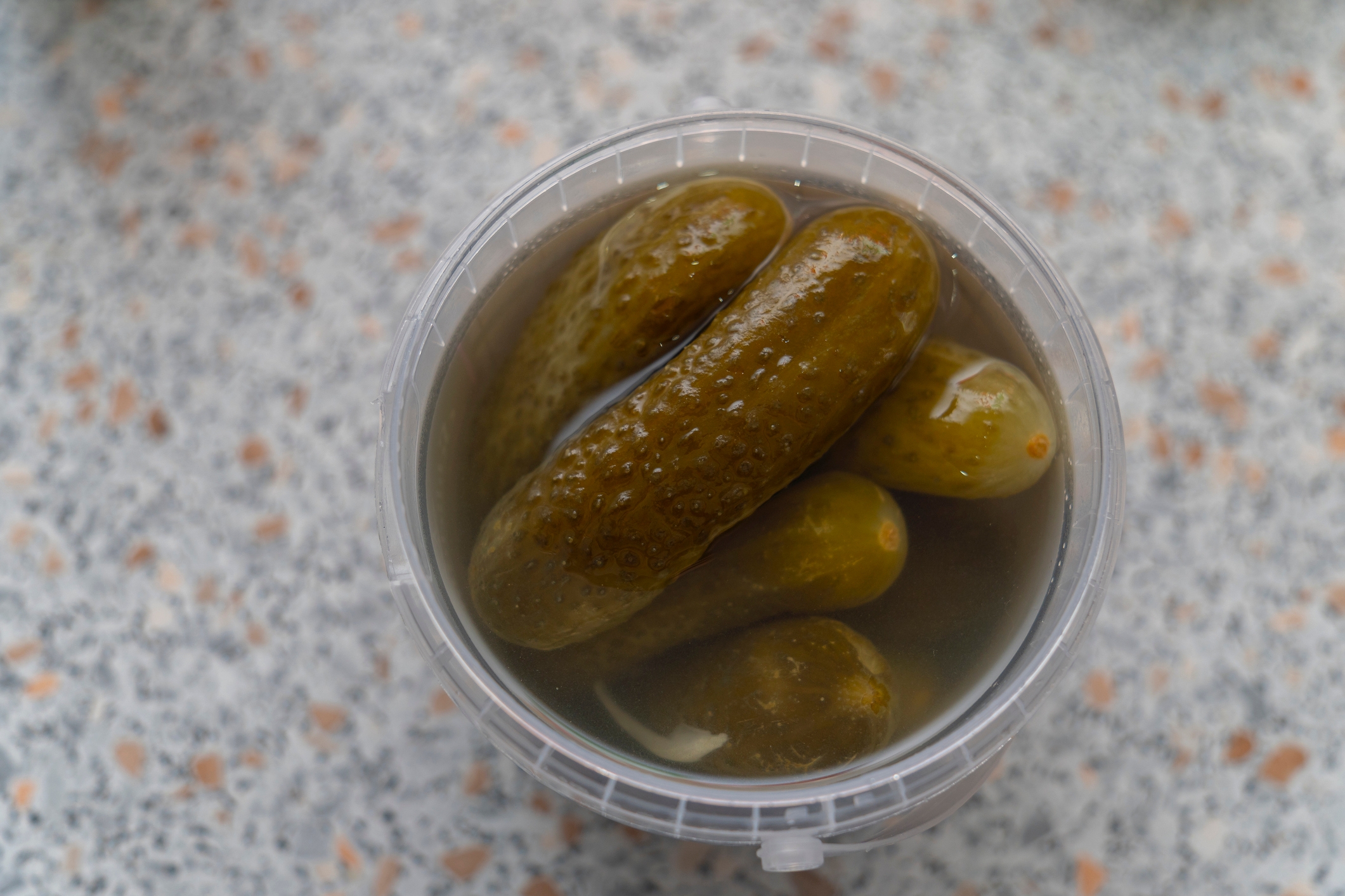Jar of pickles successful  brine connected  a speckled countertop
