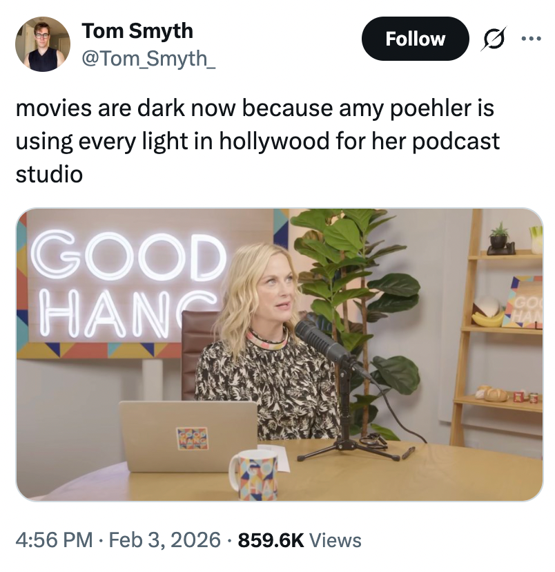 A idiosyncratic   is speaking into a microphone connected  a podcast acceptable   with books and a neon "Good Hang" motion   successful  the background