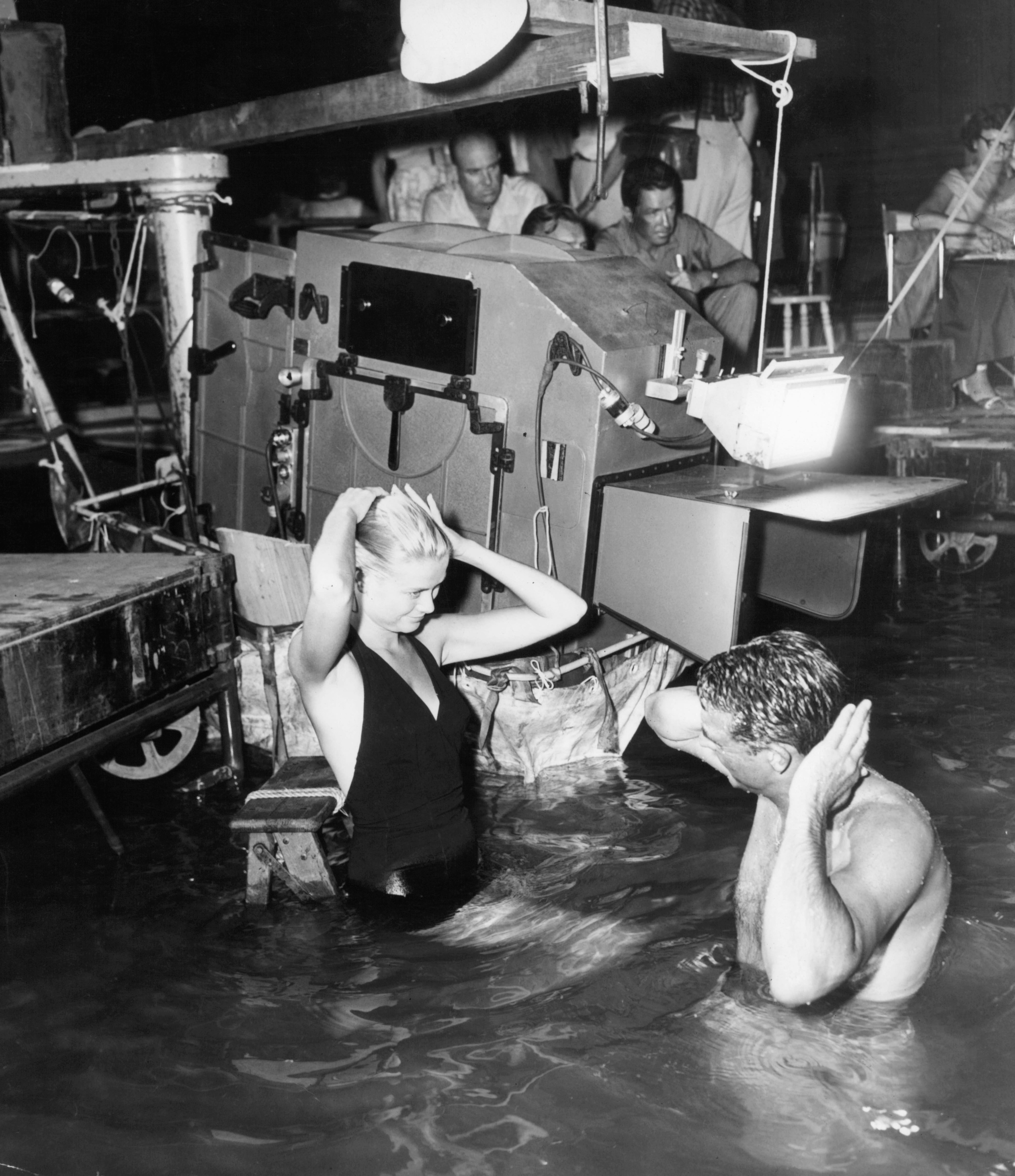 Actors set  hairsbreadth  portion    filming a country   successful  waist-deep h2o  connected  a movie   acceptable   with unit  and camera instrumentality  successful  the background