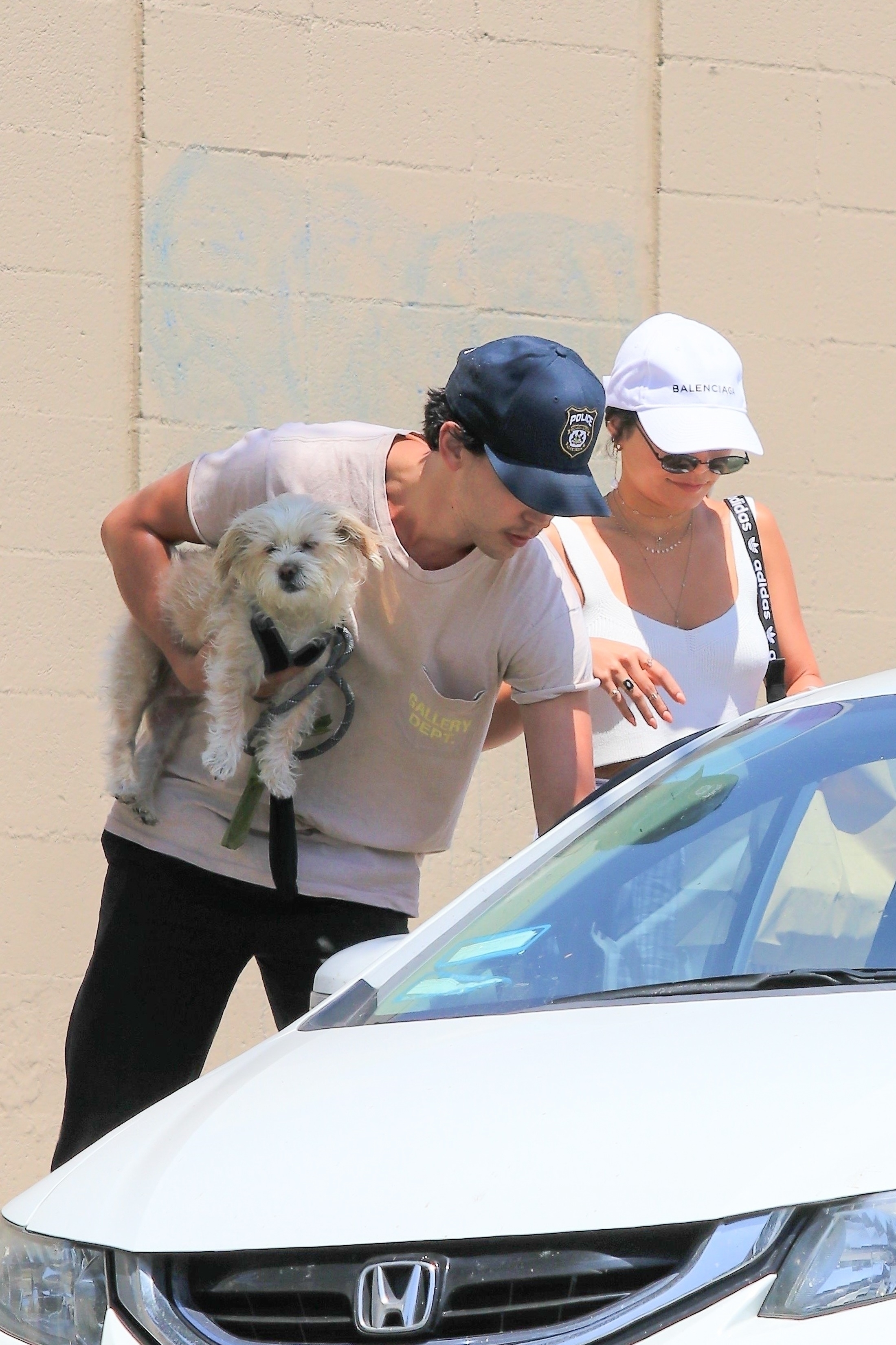 Austin holding a tiny  canine  adjacent  to a Vanessa
