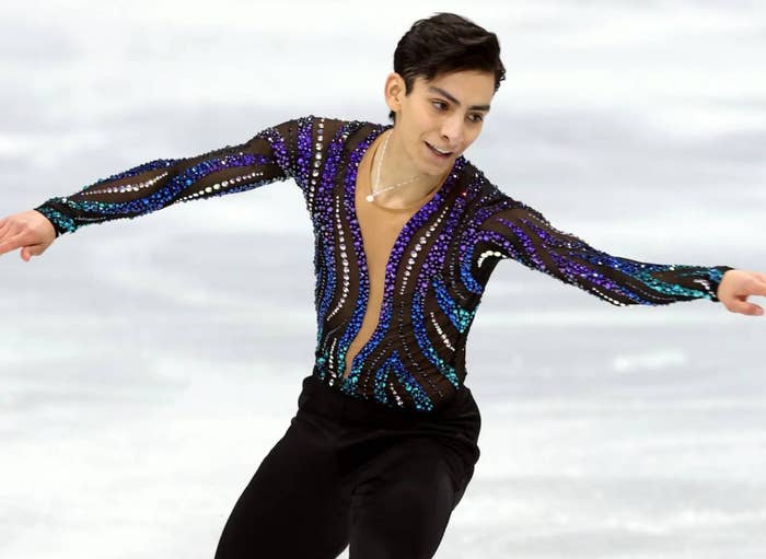 Figure skater performing on ice, wearing a patterned, form-fitting costume with sparkling details