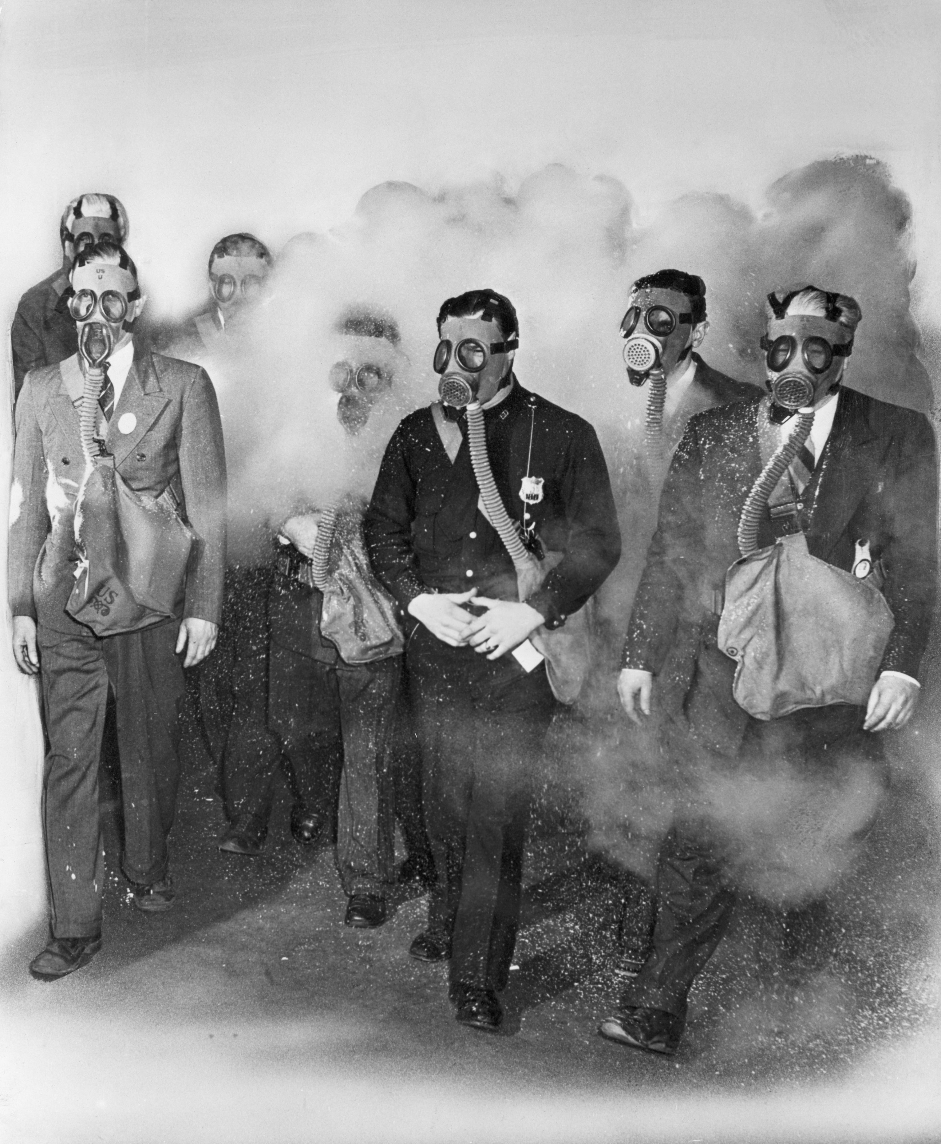 Group of men wearing state  masks walking done  a unreality  of smoke, each   carrying a satchel. They are participating successful  a humanities  information   demonstration