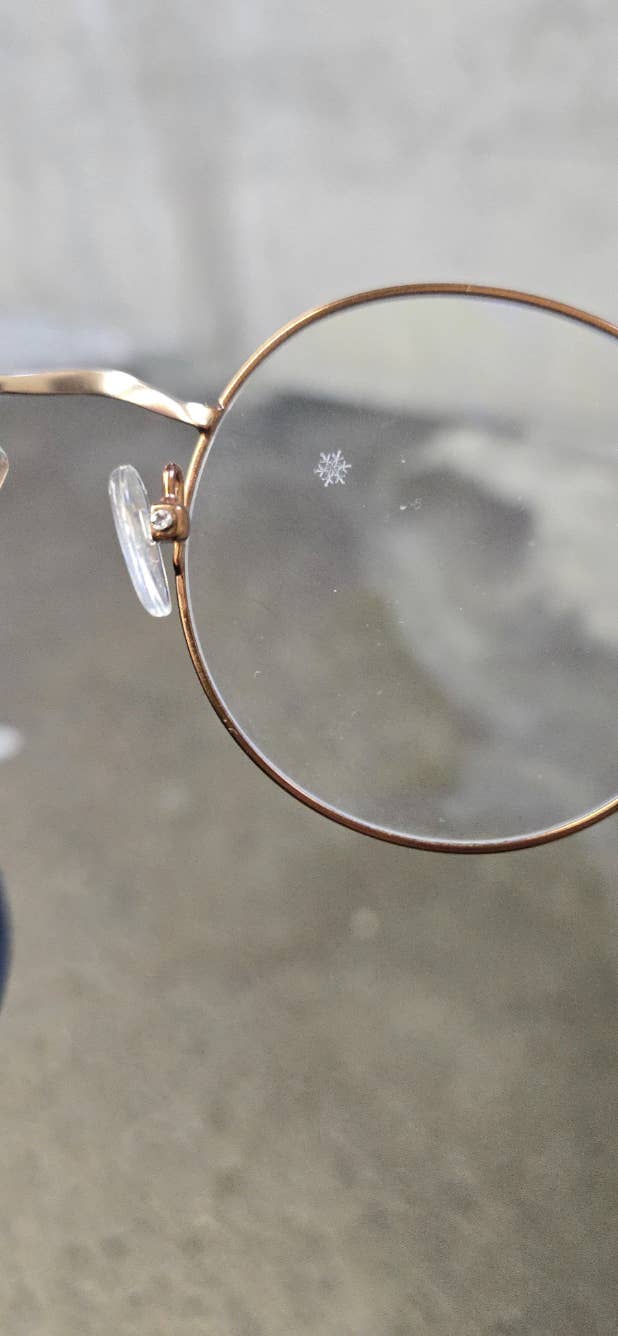 Close-up of eyeglasses with a snowflake plan  connected  the lens