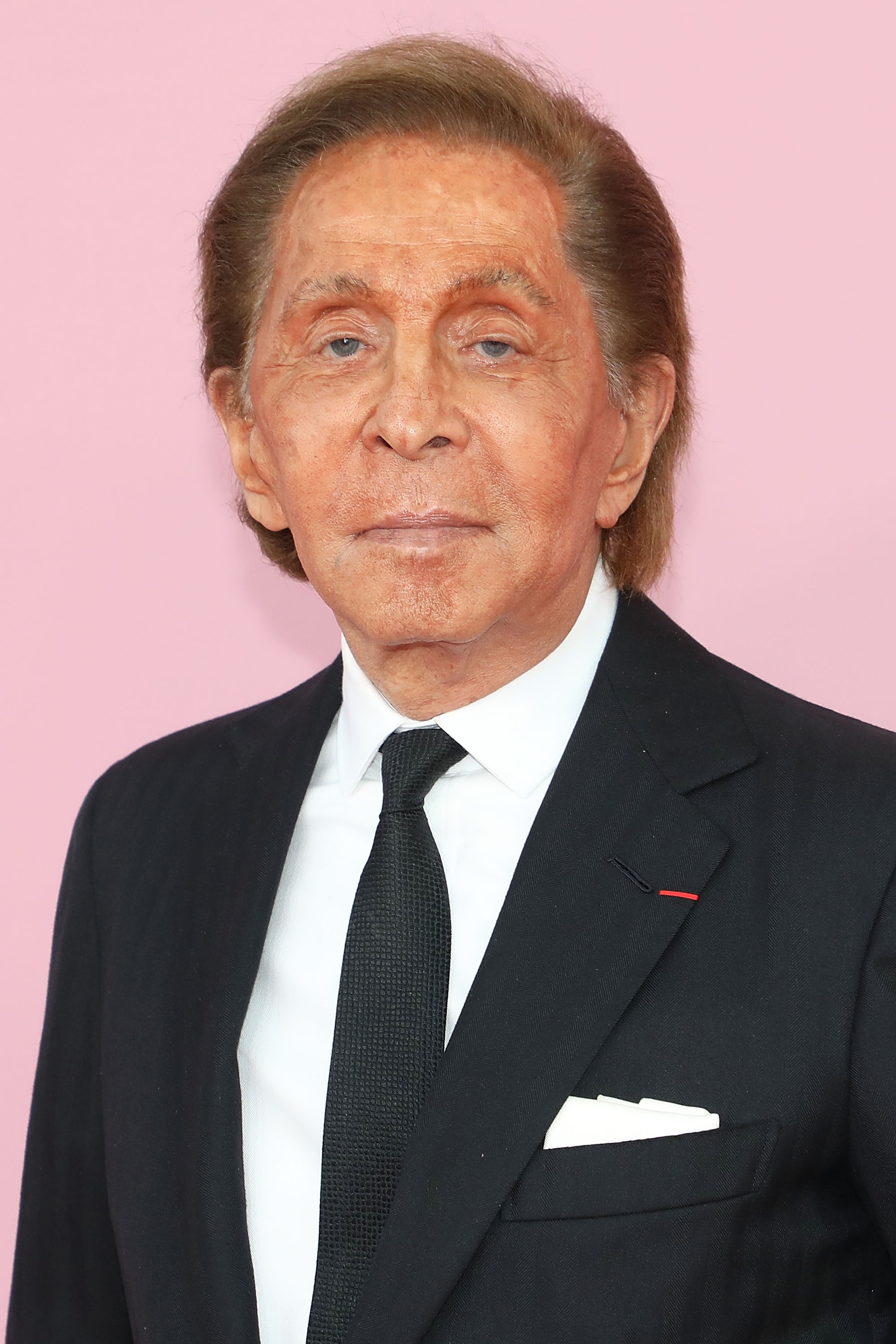 Jeg vet ikke hvem dette er, men personen har på seg en formell dress med en hvit lomme mot en vanlig bakgrunn