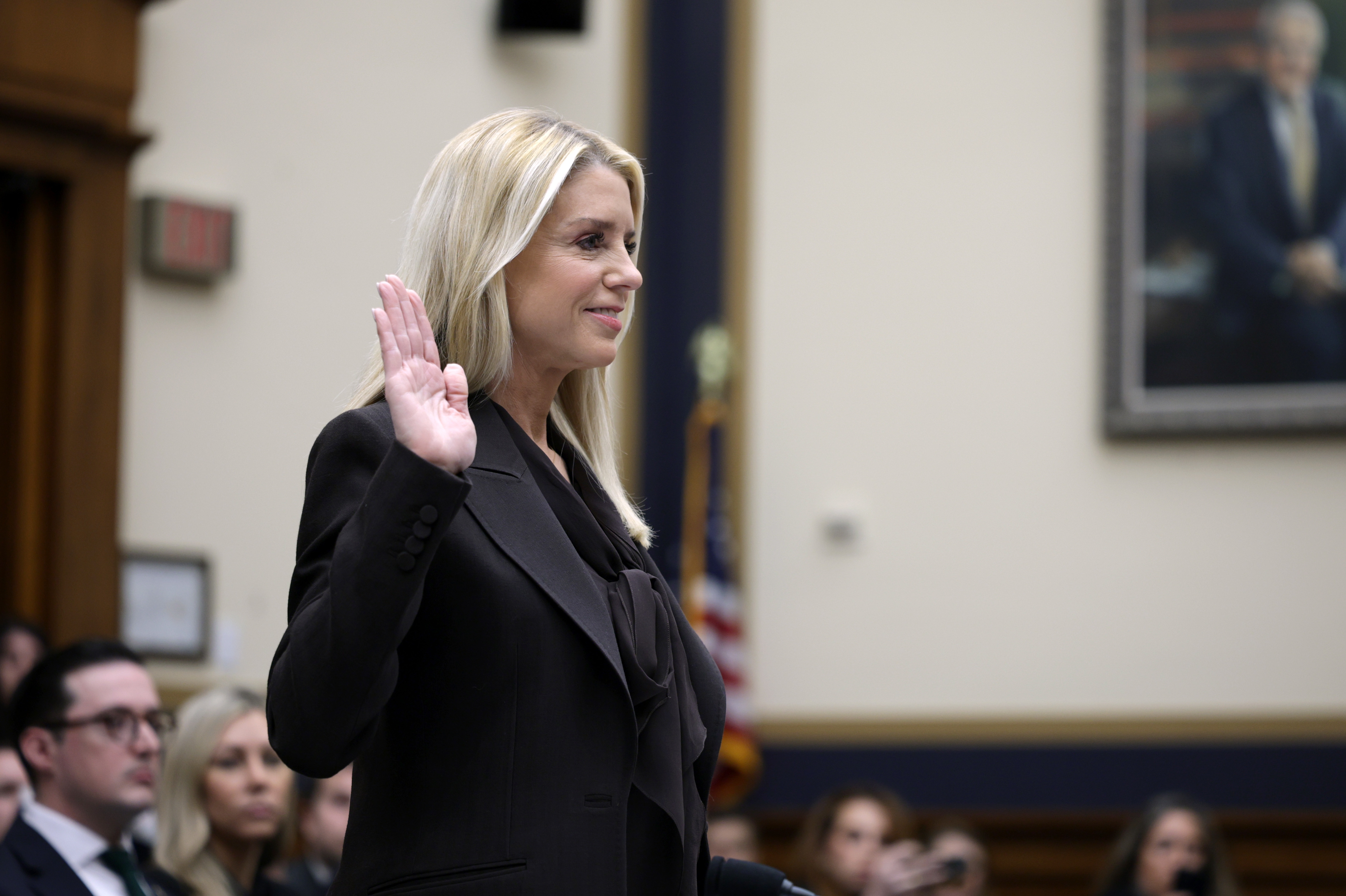 Person wearing a ceremonial  suit   taking an oath successful  a courtroom setting, with attendees successful  the background
