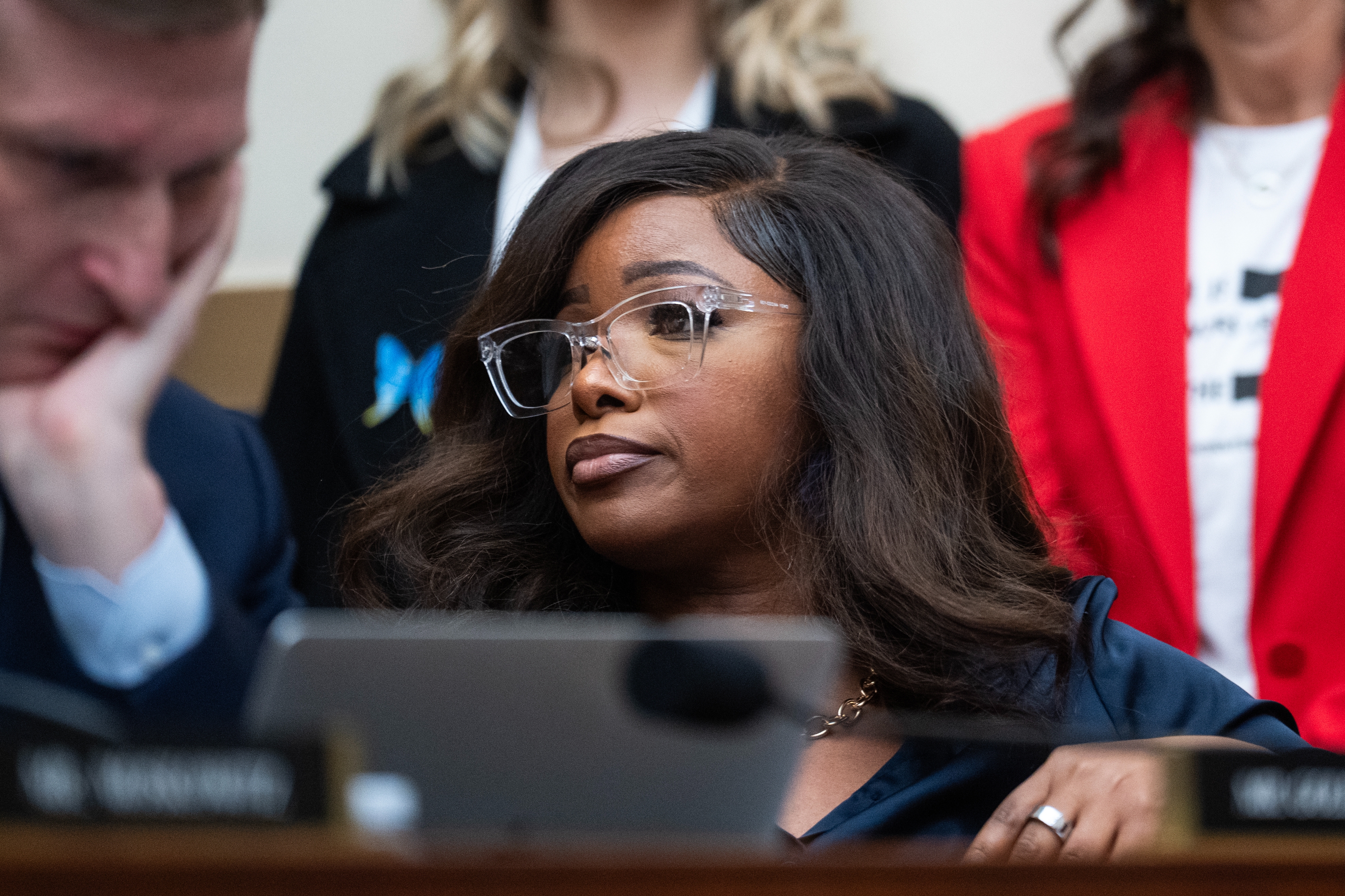 A idiosyncratic   wearing glasses and concern  attire listens attentively during a ceremonial  gathering  oregon  hearing