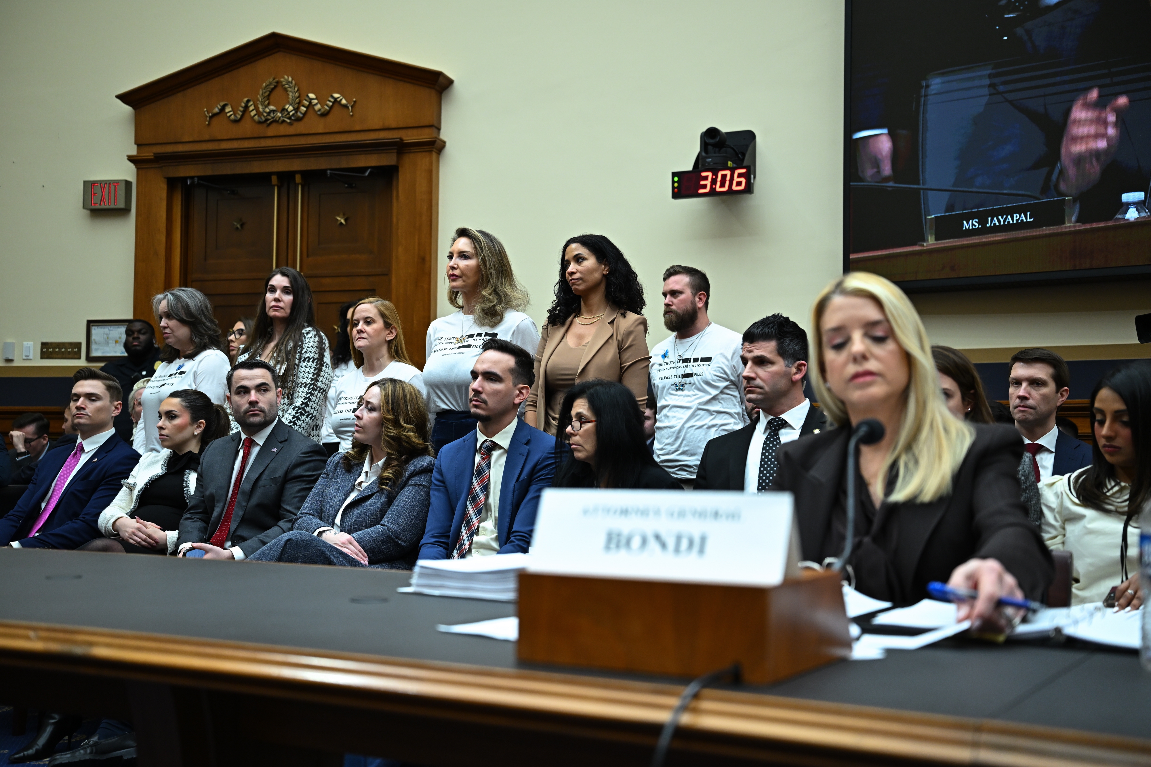 A radical  of professionally dressed individuals beryllium   and basal   during a legislature  hearing, arsenic  a pistillate   takes notes astatine  a table  labeled "Attorney General Bondi."